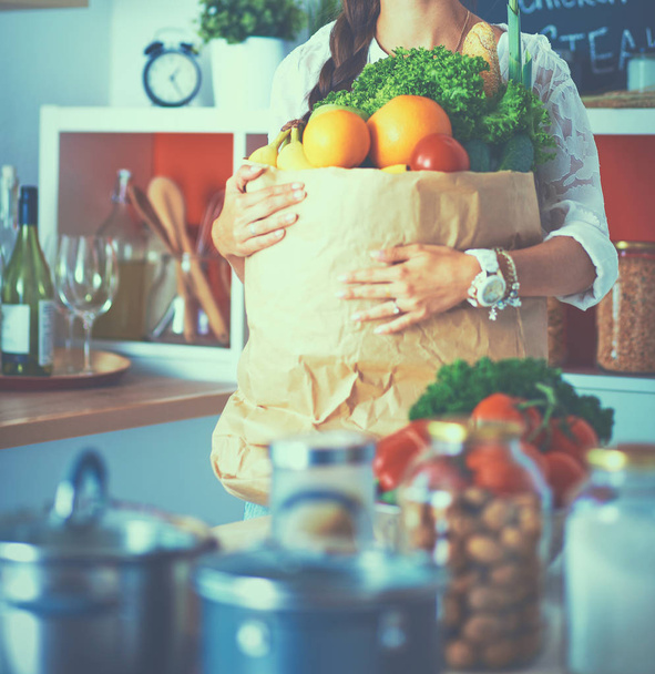 Young woman holding grocery shopping bag with vegetables - Foto, Bild