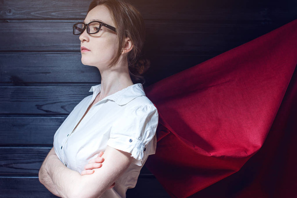 Работница офиса суперженщины, стоящая в костюме и красном плаще
 - Фото, изображение