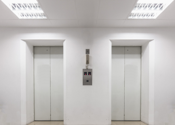 Два ліфти всередині білого будинку
 - Фото, зображення
