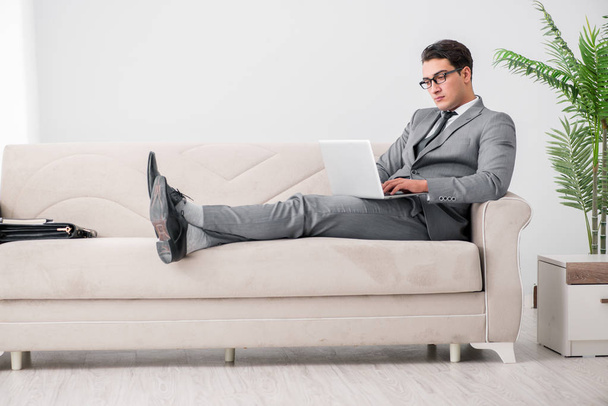 Young businessman lying on the sofa - 写真・画像