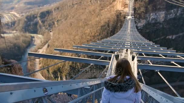 Vrouw lopen t/m hoge brug over de canyon op Skypark Aj Hackett Sotsji - Video
