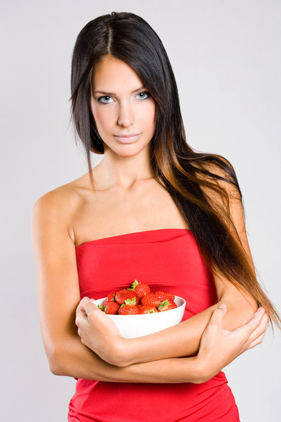 Brunette beauty with a bowl of strawberries. - Foto, Imagen