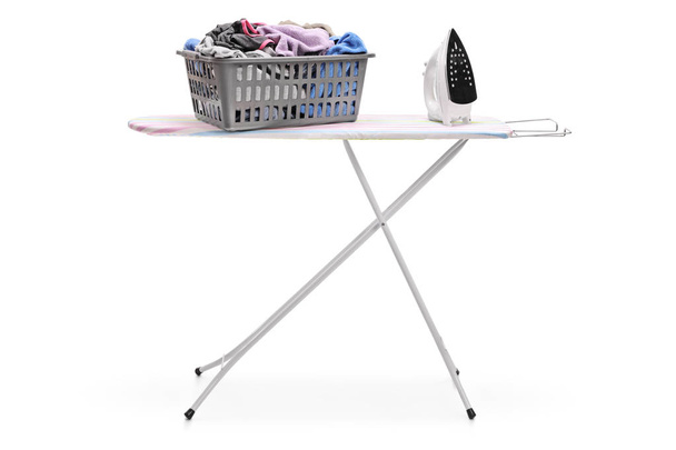 Laundry basket and an iron on an ironing board - Zdjęcie, obraz