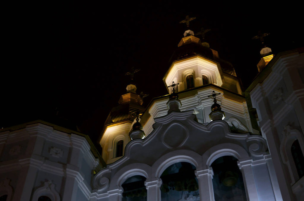 Église des Saints Porteurs de Myrrhe du Miroir. Kharkiv. Ukraine. Photo détaillée de l'église avec des dômes dorés et des décors en relief la nuit
 - Photo, image