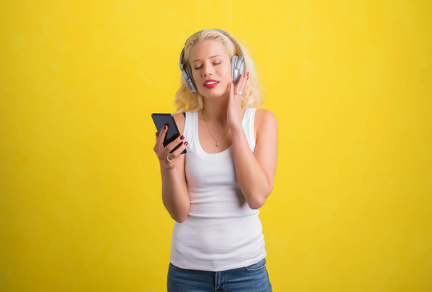 Woman listening to music on wireless headphones - Photo, Image