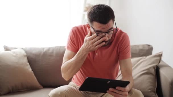 man with tablet pc tired from eyeglasses at home - Záběry, video