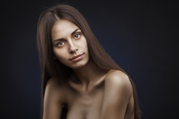 Beautiful woman with long hair on dark background - Фото, зображення