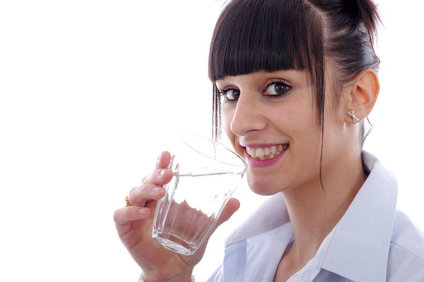 mujer joven bebe un vaso de agua, sobre blanco
 - Foto, imagen