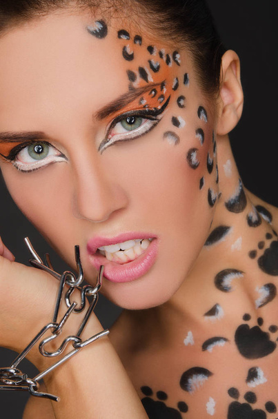 beautiful woman with animal face art and bracelet - Fotó, kép