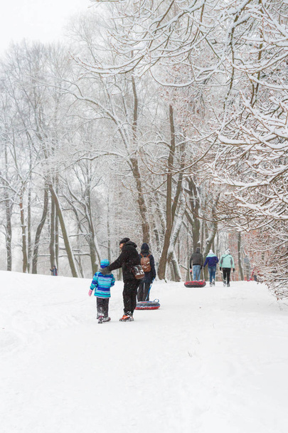 People walk in winter Park in the snow - Fotoğraf, Görsel