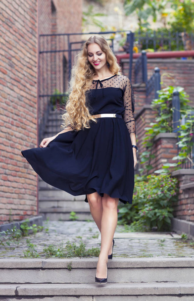 Outdoor fashion portrait of stylish lady wearing trendy black dr - Fotoğraf, Görsel