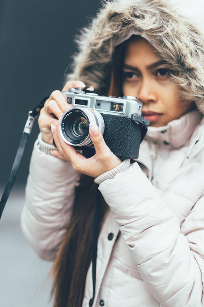 Beautiful girl photographing in cold weather, urban environment - Zdjęcie, obraz
