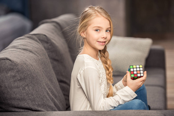 Girl playing with rubik's cube - Фото, изображение
