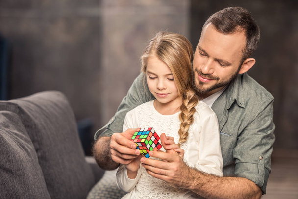 Father and daughter playing with rubik's cube - Foto, Imagem