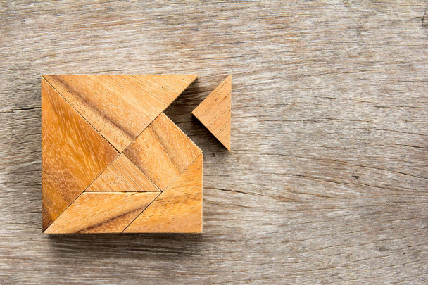 Tangram Puzzle mit einem Teil wartet darauf, die quadratische Form auf Holzgrund anzupassen (Konzept für die Erfüllung der Liebe) - Foto, Bild