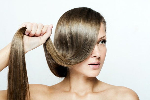mladá atraktivní žena drží vlasy - Fotografie, Obrázek