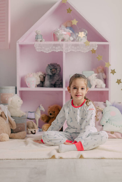 girl in pajamas in the children's room - Фото, изображение