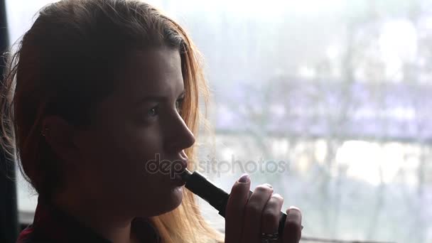 Jolie femme fume cigarette électronique et fait des nuages de fumée, adolescent est vaping, e-cig et vape stylo, mauvaises habbits de personnes
 - Séquence, vidéo
