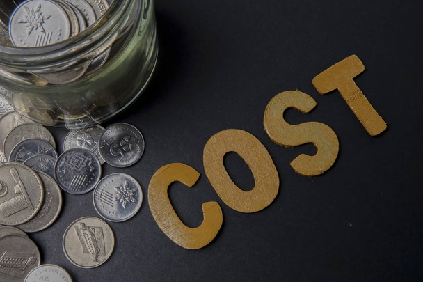 Paire de ciseaux réduit les dépenses d'affaires mot COST pour économiser le coût. Concept d'entreprise et faible luminosité
. - Photo, image