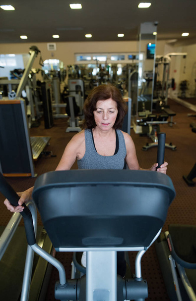 Beautiful fit senior woman in gym doing cardio work out. - Zdjęcie, obraz