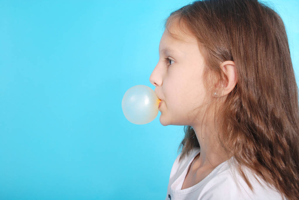 Chica joven haciendo burbuja con goma de mascar
 - Foto, imagen