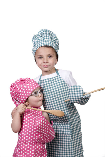 Bambini piccoli, con cucchiaio di legno e costume da cucina
 - Foto, immagini