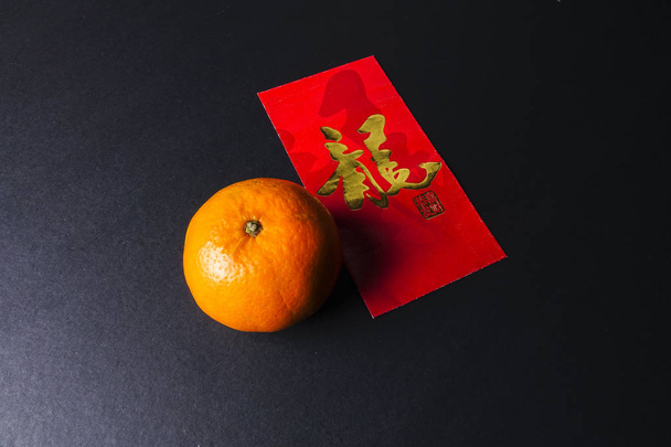 Décorations du Nouvel An chinois, paquets rouges et oranges mandarines, lettre chinoise dorée signifie chance
 - Photo, image