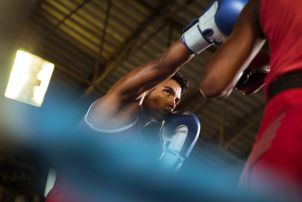 Két férfi sportolók küzdelem a boksz gyűrűt - Fotó, kép