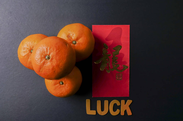 Формулировка LUCK, ang pow или красные пакеты и мандаринские апельсины, золотая китайская буква означает удачу
 - Фото, изображение