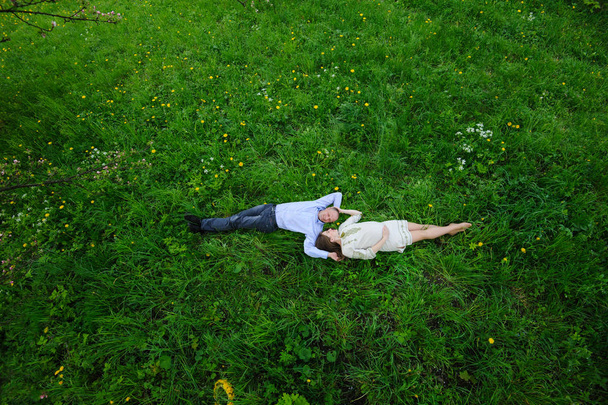 беременная женщина с мужем в цветущем саду
 - Фото, изображение