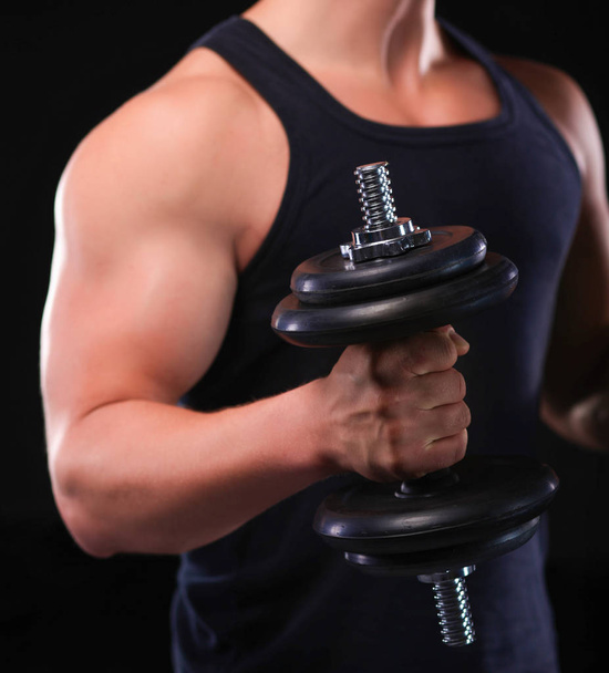 Handsome muscular man working out with dumbbells - Photo, image