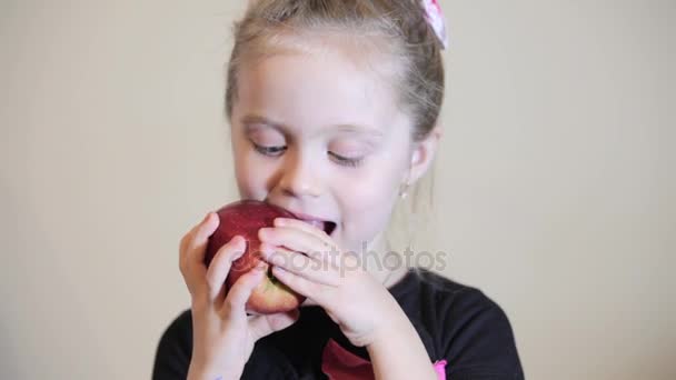 little girl eats large apple - Séquence, vidéo
