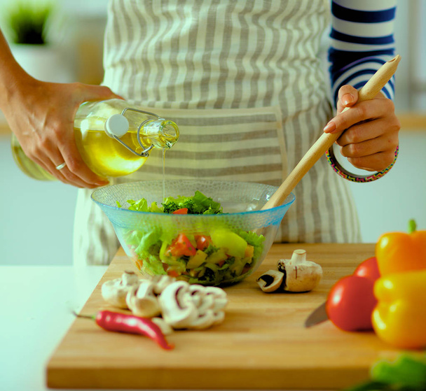 Young woman mixing fresh salad - Foto, imagen