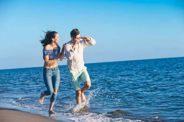 Щаслива пара біжить на пляжі
 - Фото, зображення