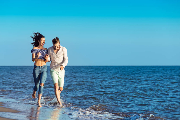 happy couple running on the beach - Фото, изображение