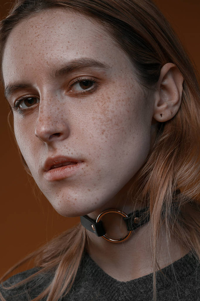Portrait of a beautiful girl with freckles in studio on a brown background - Foto, immagini