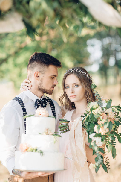 bride and groom holding a wedding cake - Fotografie, Obrázek