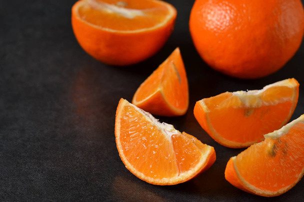 Juicy, fresh slices of orange on a black background - Fotó, kép