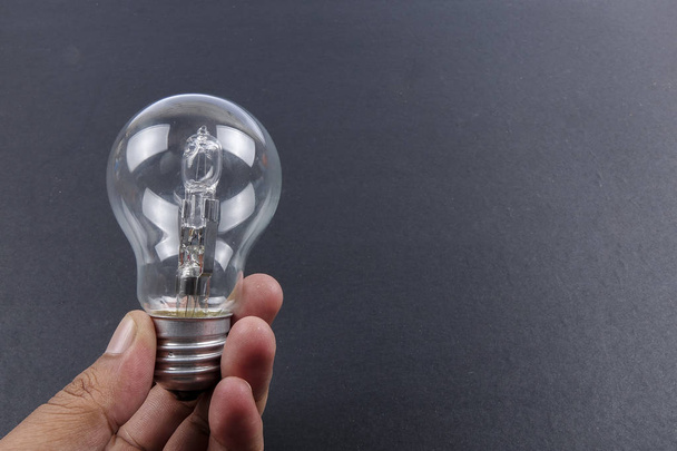 Ideia conceito palavra IDEA. Luz da lâmpada sobre fundo cinzento. Baixa luz
 - Foto, Imagem