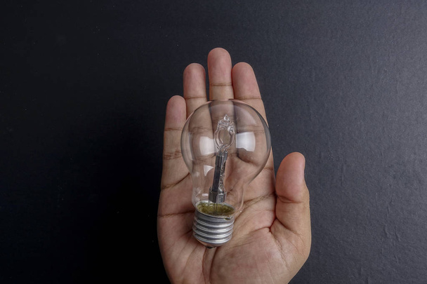 Idea concept word IDEA. Light of bulb on grey background. Low light - Fotoğraf, Görsel