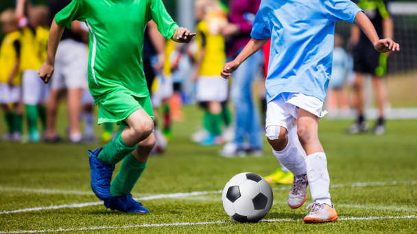 Laufen junge Fußballspieler. Fußballer kicken Fußballspiel. Jugendfußballer laufen dem Ball hinterher. Fußballmannschaft im Hintergrund - Foto, Bild