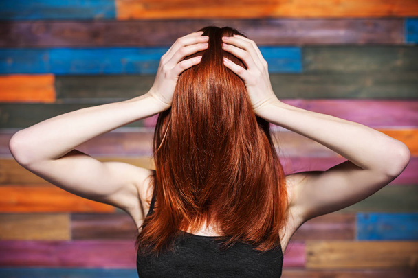 Faceless woman holding her head. Red hair covered face - Fotó, kép