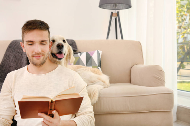 man reading book with dog - Foto, afbeelding