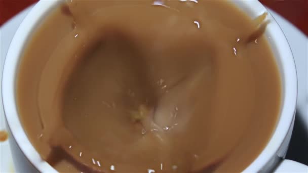 Morceau de sucre gouttes dans une tasse de café avec du lait. Gros plan
 - Séquence, vidéo