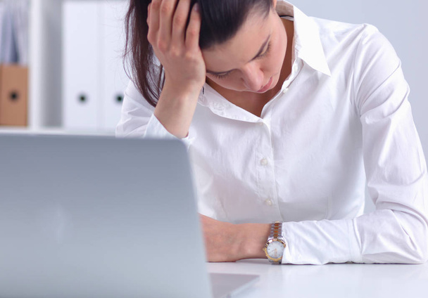 Stressed businesswoman sitting at desk in the office - Photo, image