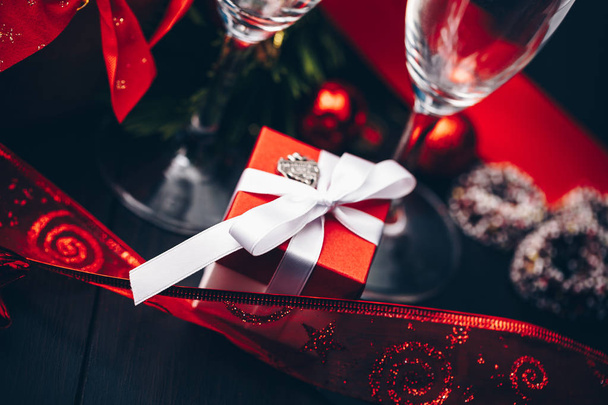 Noel ve yeni yıl. Şampanya gözlük mumlar, panettone ve kırmızı saten fiyonklu hediye paketi. Boşluk. Festival kavramı - Fotoğraf, Görsel