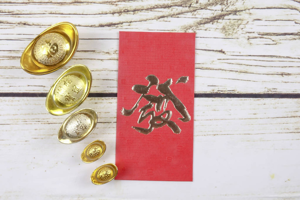 Altın külçeler ve kırmızı para paket için Çin yeni yılı ahşap arka plan üzerinde şenlikli. Şans, zenginlik ve resimde görüldüğü gibi refah Çince karakter anlamına gelir. - Fotoğraf, Görsel