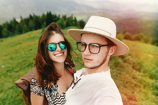 élégant couple hipster voyageant et souriant au sommet de la montagne
 - Photo, image