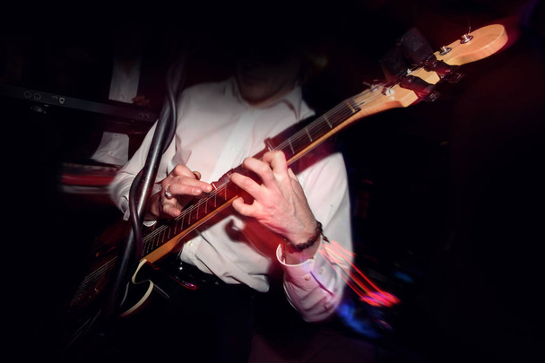 κομψό κιθαρίστας παίζει σε μια σκηνή - Φωτογραφία, εικόνα