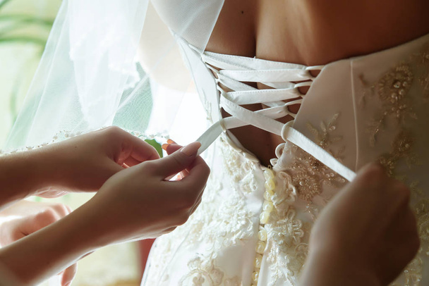 bridesmaid helping getting dressed bride - Photo, Image